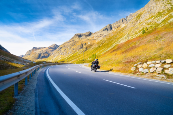 A team of motorcyclists travels the beautiful roads in the mountains. The road and the turns. Traveling on a motorcycle. Recreation and active life.