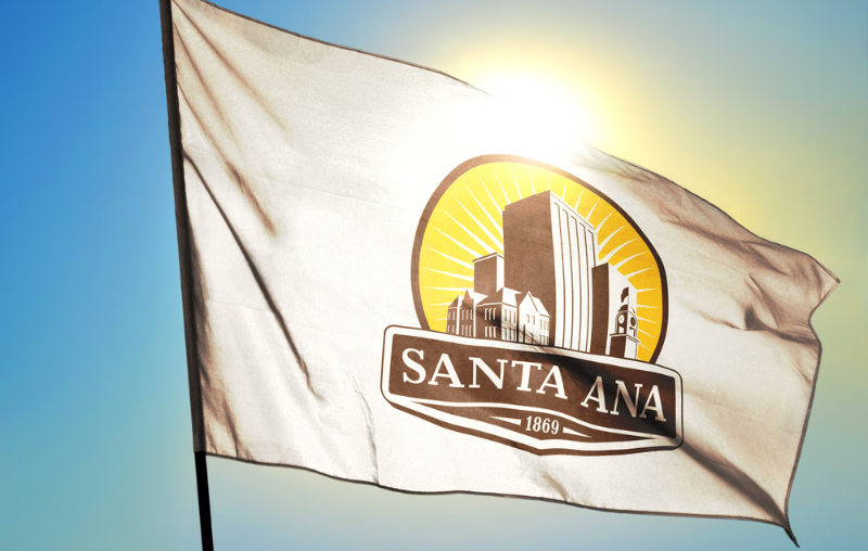 Santa Ana of California of United States flag waving on the wind in front of sun