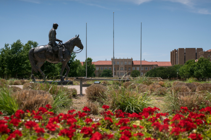 Lubbock, Texas - June 5, 2021: Texas Tech University Will Rogers and Soapsuds statue on Amon G. Carter plaza with campus flowers