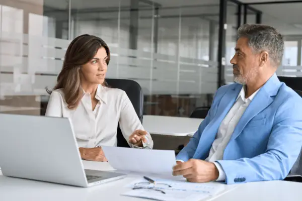 Personal injury lawyer consulting with client about car accident settlement estimate in modern office