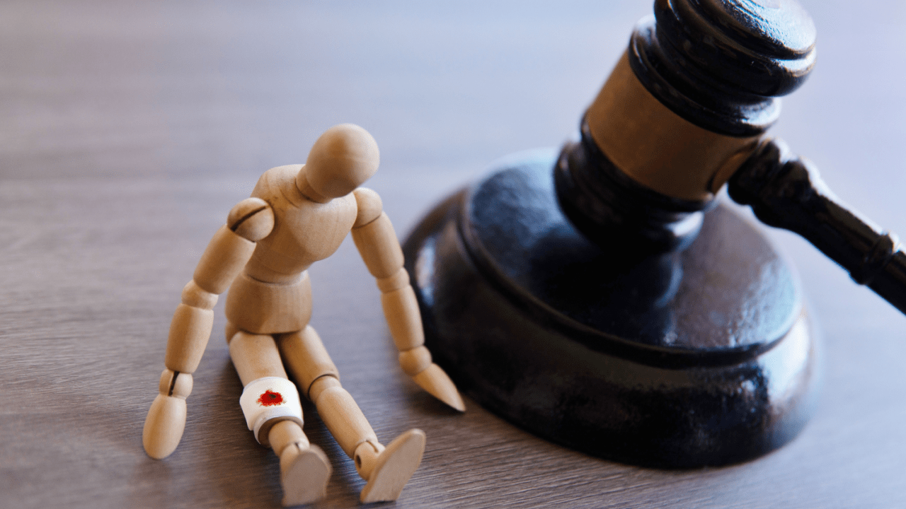 Injured wooden figure beside judge’s gavel — do most personal injury cases win?