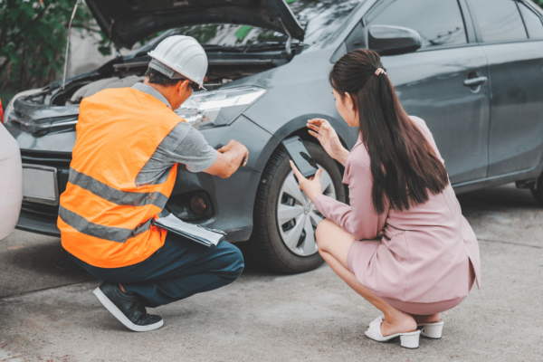 Insurance adjuster inspects vehicle with driver — how do you win a car accident settlement?