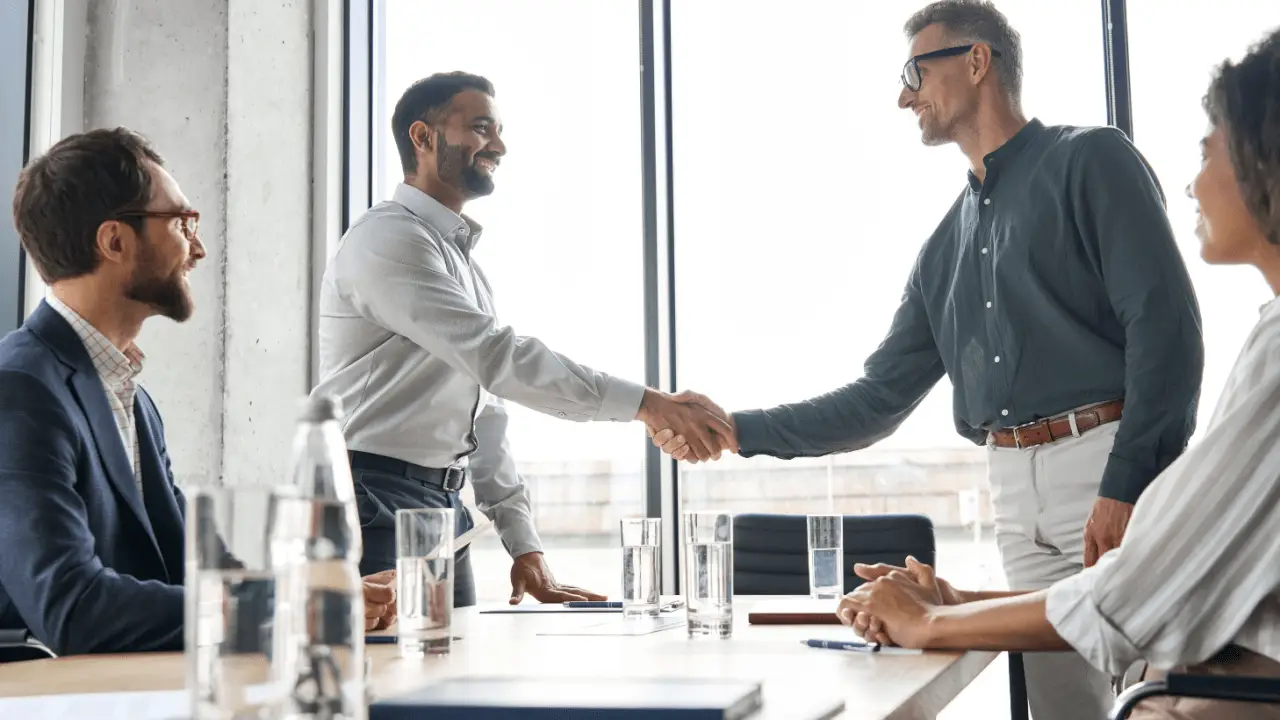 Two professionals shaking hands during a meeting — what percentage of personal injury cases settle out of court?