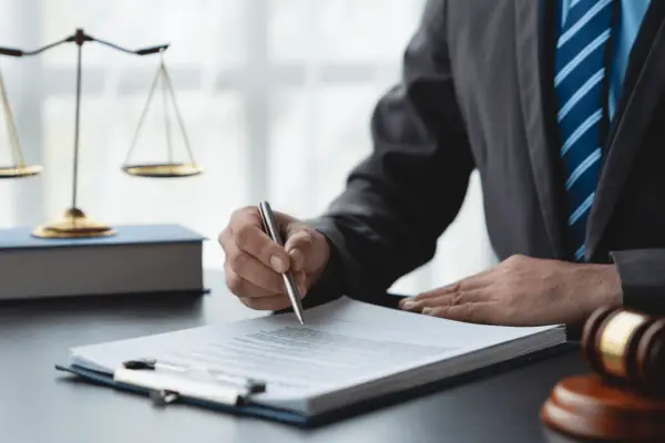 Attorney reviewing legal documents do insurance companies pay attorney fees consultation scales of justice