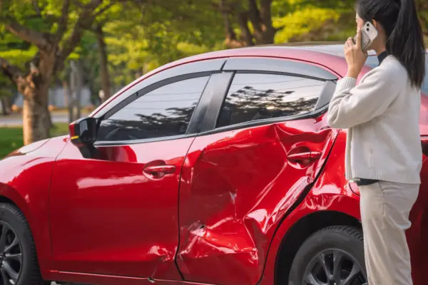 Woman on phone after car accident wondering how much is my car worth after being in an accident