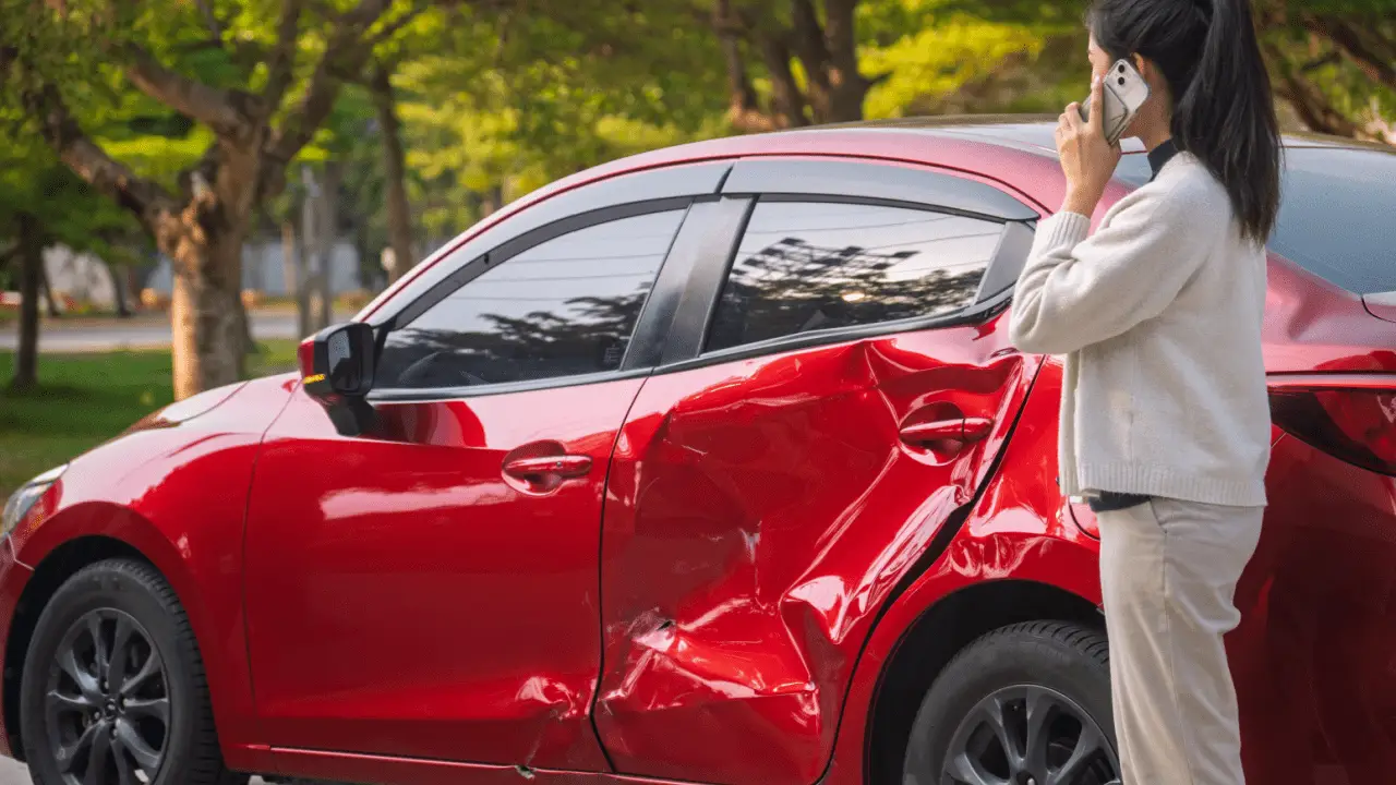 Woman on phone after car accident wondering how much is my car worth after being in an accident