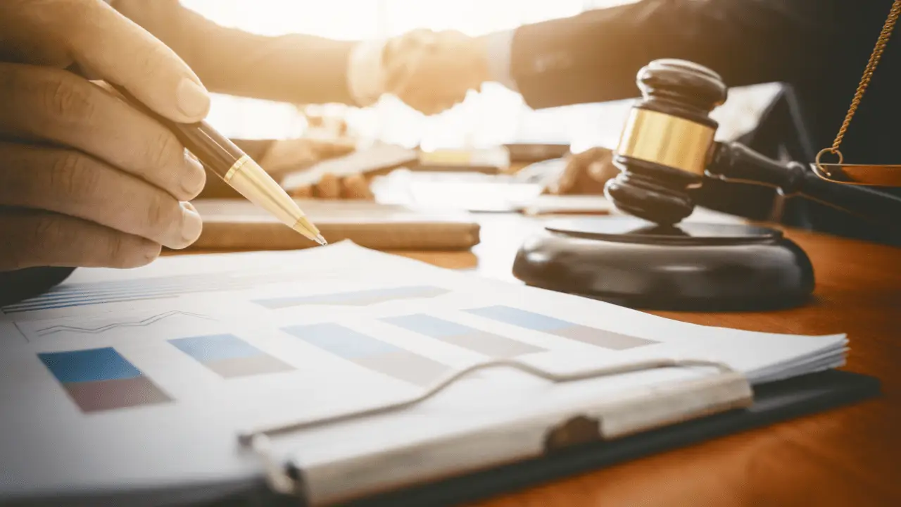 Person calculating how much should I ask for a settlement with legal documents and gavel