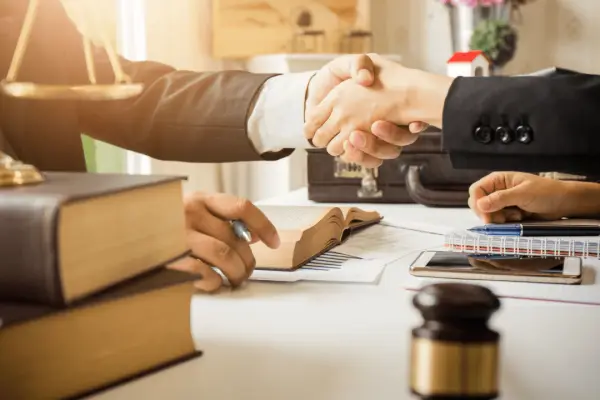 Professional handshake between client and attorney discussing should I ask an attorney how much my accident case is worth during legal consultation