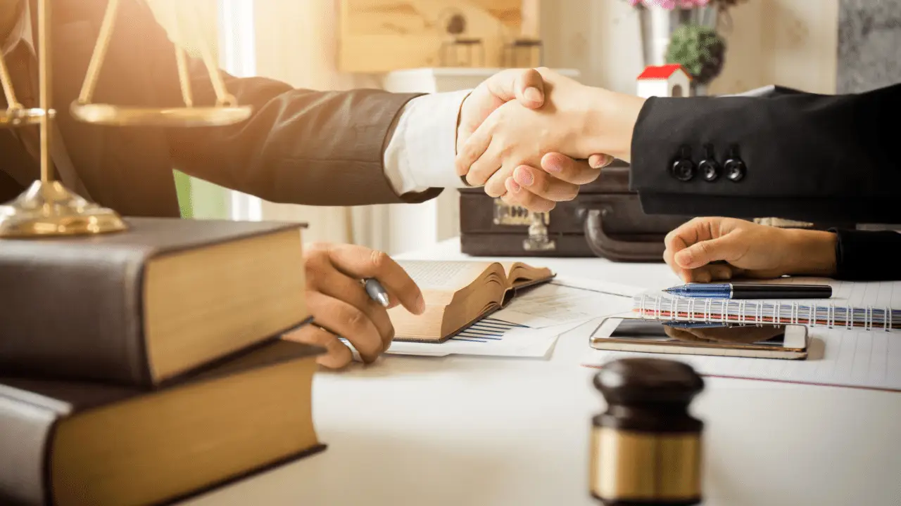 Professional handshake between client and attorney discussing should I ask an attorney how much my accident case is worth during legal consultation