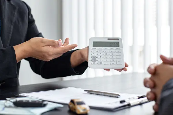 Personal injury attorney calculating what are the odds of winning a car accident lawsuit with calculator and legal documents