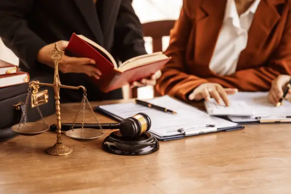 Lawyers discussing what is considered a good settlement with legal documents and scales of justice