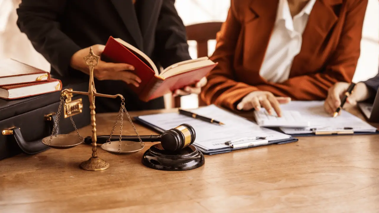 Lawyers discussing what is considered a good settlement with legal documents and scales of justice