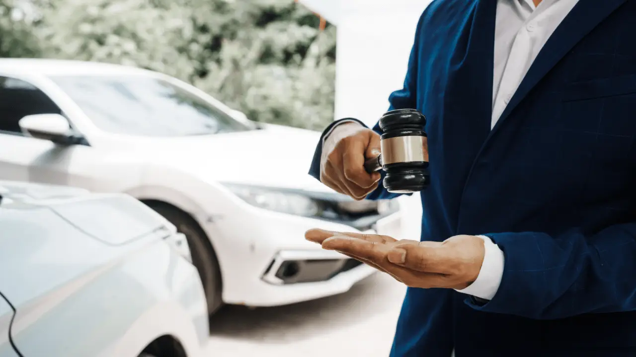 Are traffic lawyers worth it - Traffic lawyer holding gavel near white car representing legal representation for traffic violations