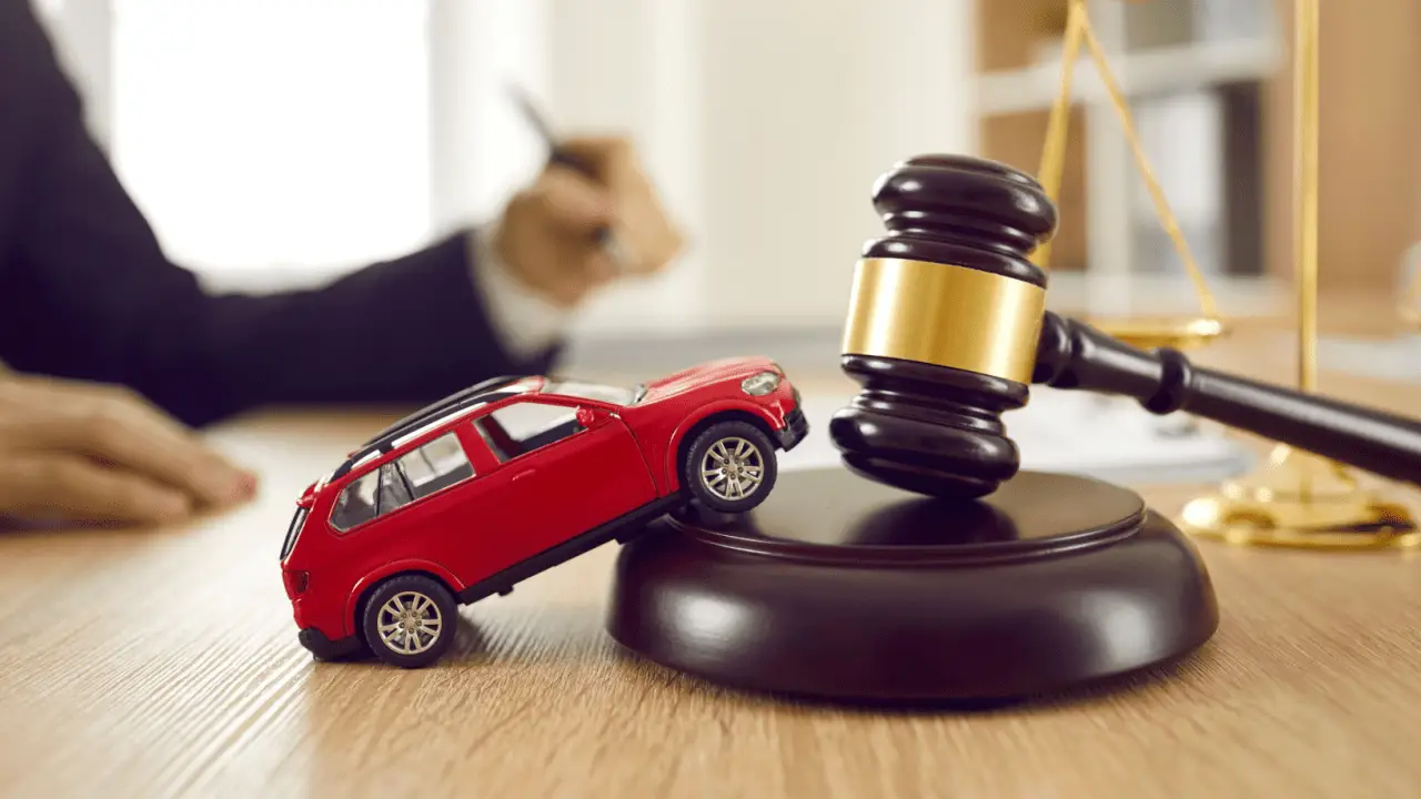 Red toy car with judge gavel representing do car accident cases go to court legal process
