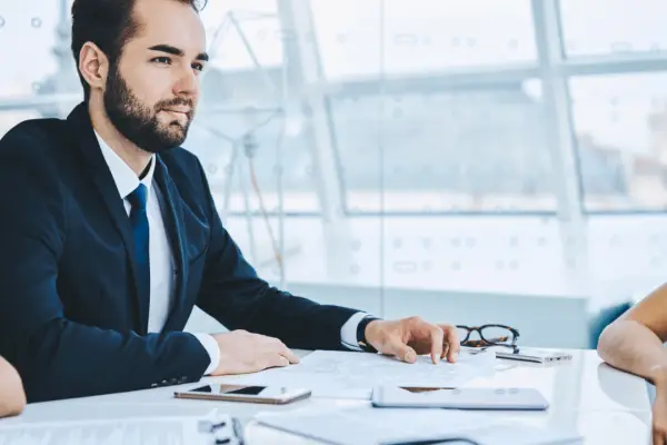 Professional attorney in navy suit meeting with client at conference table discussing is there anything you shouldn't tell your lawyer during legal consultation
