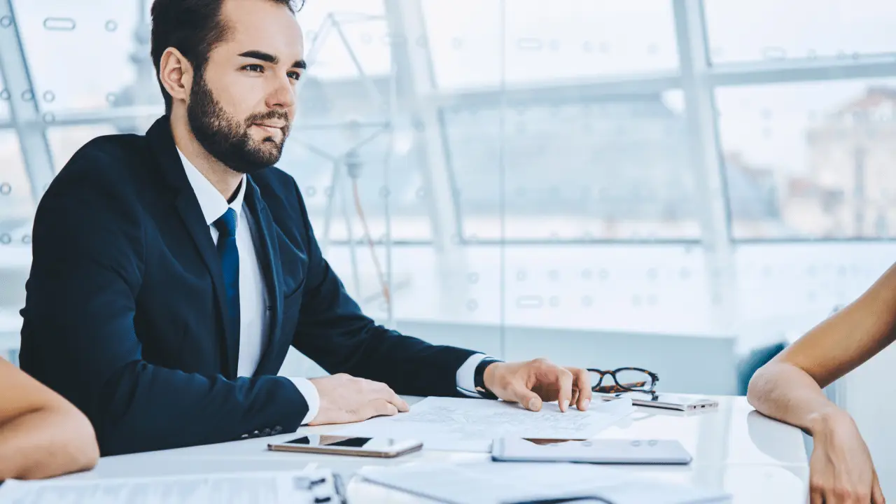 Professional attorney in navy suit meeting with client at conference table discussing is there anything you shouldn't tell your lawyer during legal consultation