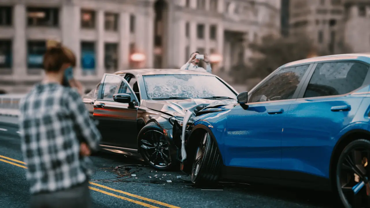 Car accident scene showing damaged vehicles where drivers wonder should I call lawyer or insurance first
