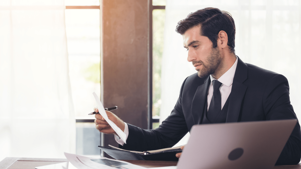 Professional in suit working at desk reviewing documents - what percentage do most injury lawyers take for contingency fee cases