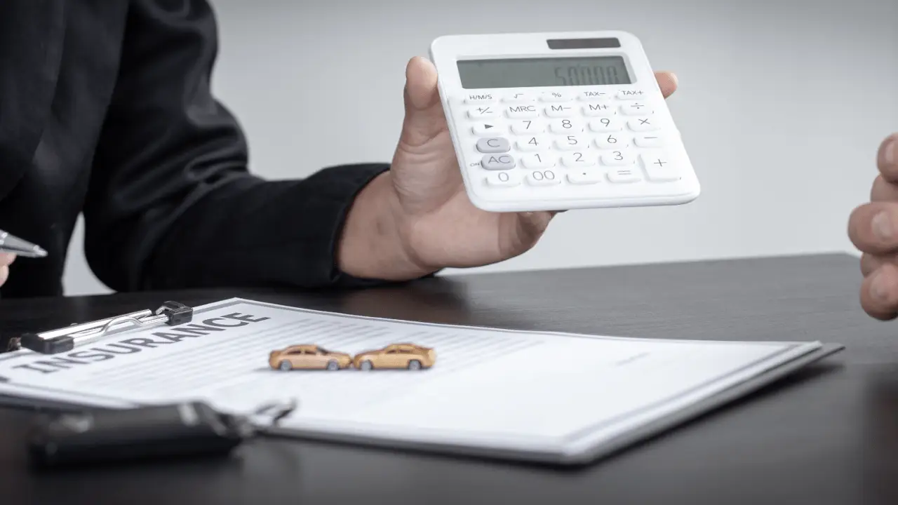 Car accident lawyer calculating settlement compensation with calculator and insurance documents