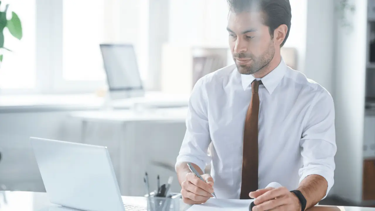 Professional attorney in white shirt and brown tie working at desk with laptop reviewing documents about can a personal injury lawyer drop your case