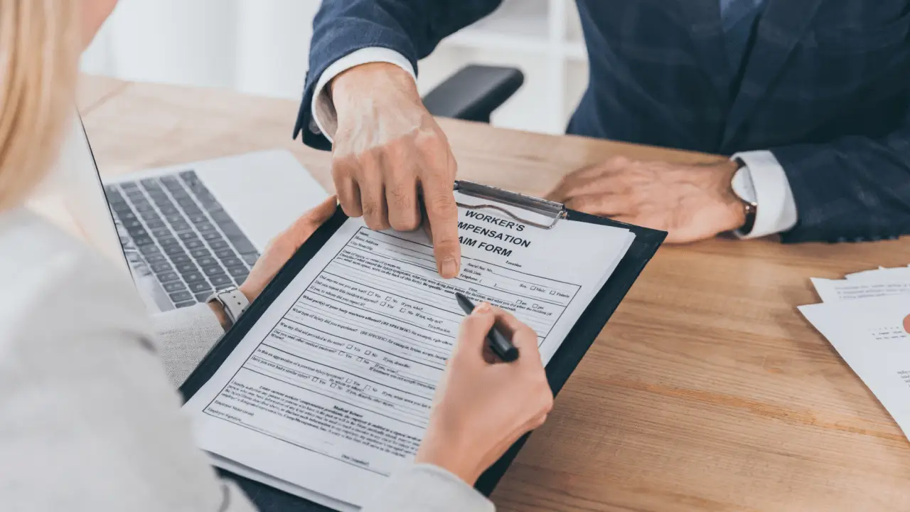 Person completing workers compensation claim form with attorney guidance for maximum compensation recovery