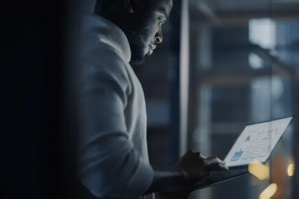 Man researching average settlement for car accident back injury on laptop with data charts