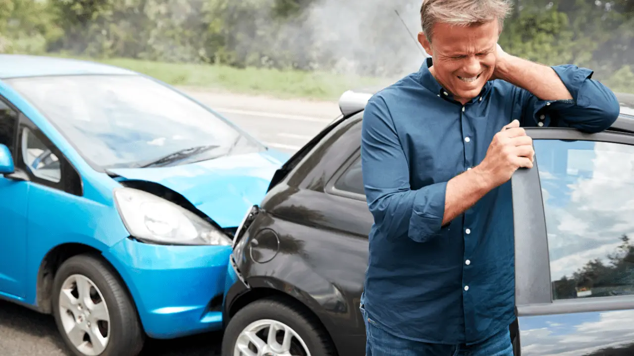 Man holding neck after car accident showing whiplash injury that leads to average settlement for whiplash car accident claims