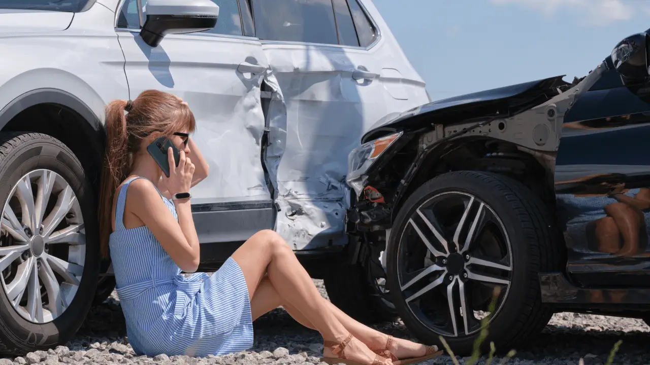 Woman on phone after car accident wondering do I need a lawyer to sue after a car accident