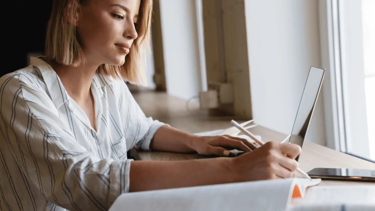 Young woman researching how long after a car accident do you get a settlement while taking notes on laptop at home