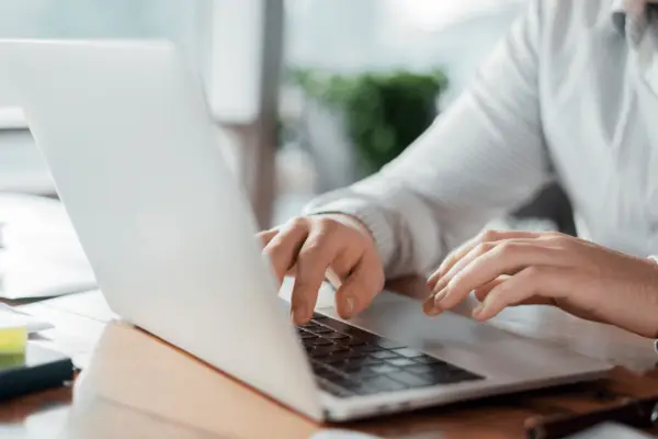 Professional woman researching how much are most car accident settlement while working on laptop in bright office setting