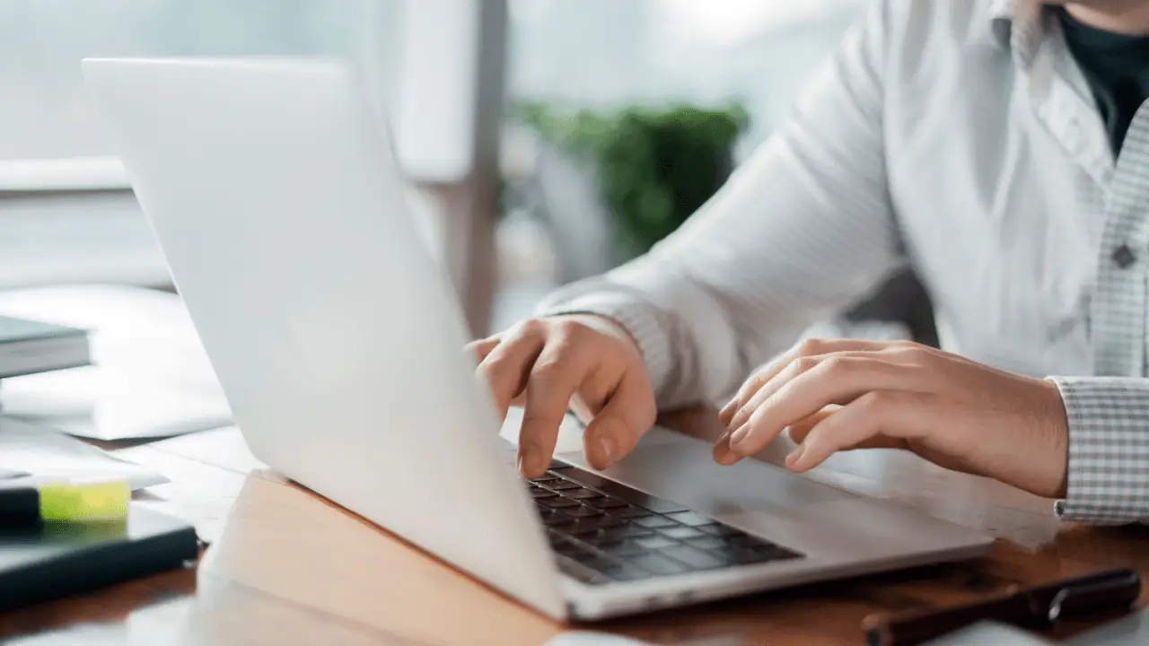 Professional woman researching how much are most car accident settlement while working on laptop in bright office setting