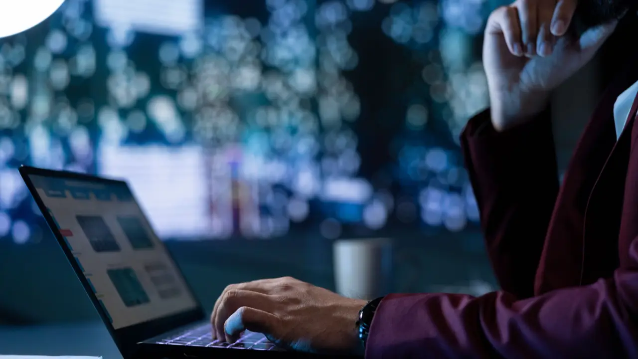 Person analyzing factors that affect car accident settlement amounts on laptop computer