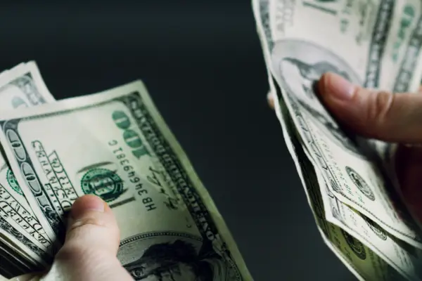 Person counting cash settlement money representing how much should you get if you get hit by a car compensation