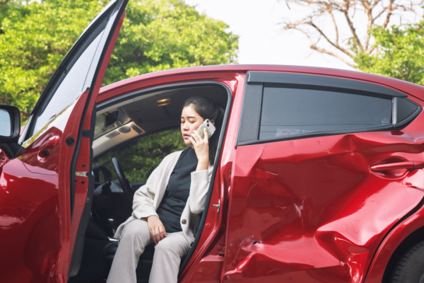 Woman calling insurance company after car accident to understand what happens if you are at fault in a car accident lawsuit