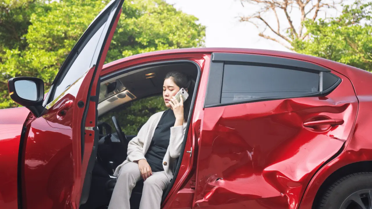 Woman calling insurance company after car accident to understand what happens if you are at fault in a car accident lawsuit