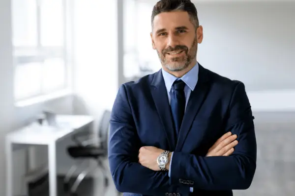 Professional motorcycle accident lawyer in navy suit standing confidently in modern office