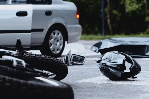 Motorcycle accident scene showing crashed bike and helmet determining how much compensation you get for a motorcycle accident