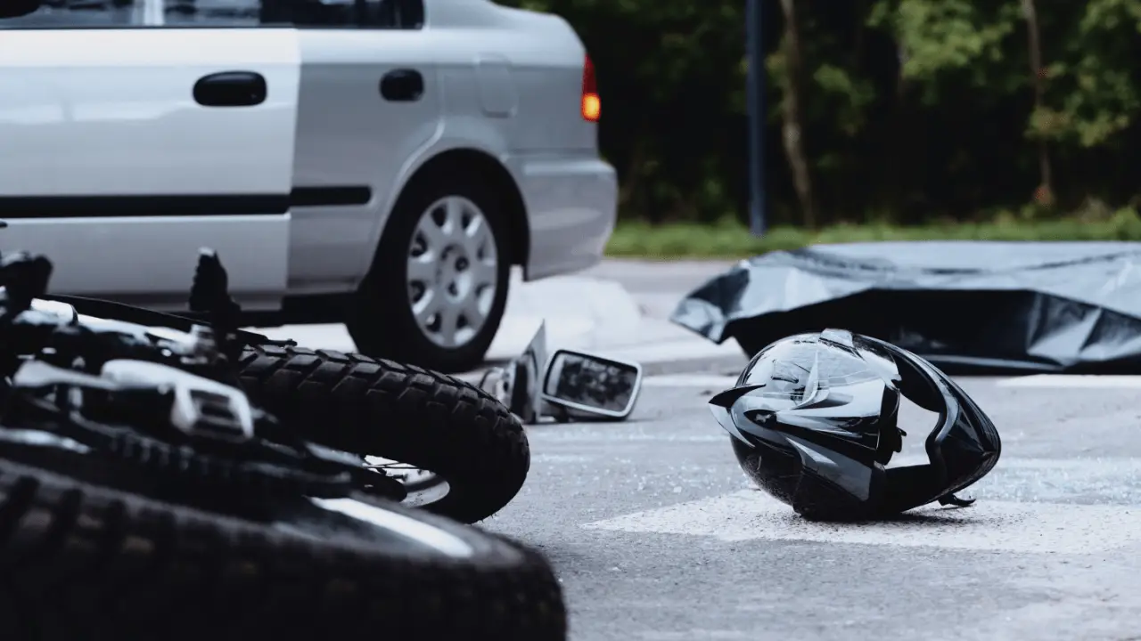 Motorcycle accident scene showing crashed bike and helmet determining how much compensation you get for a motorcycle accident