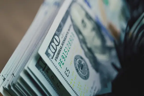 Stack of hundred dollar bills representing how much of a 250k settlement will i get after legal fees