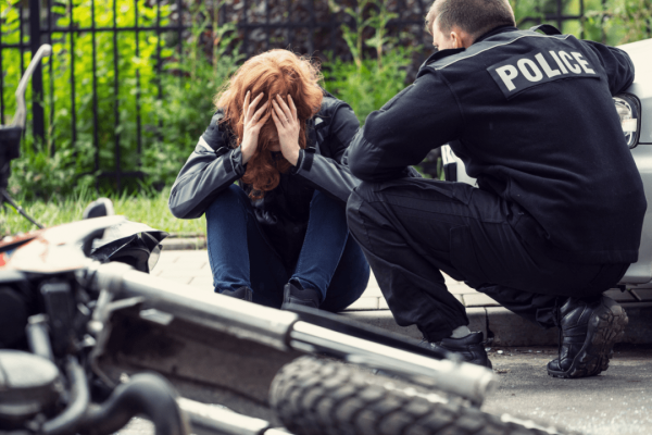 Distressed woman receiving police assistance after motor vehicle accident to determine maximum compensation eligibility