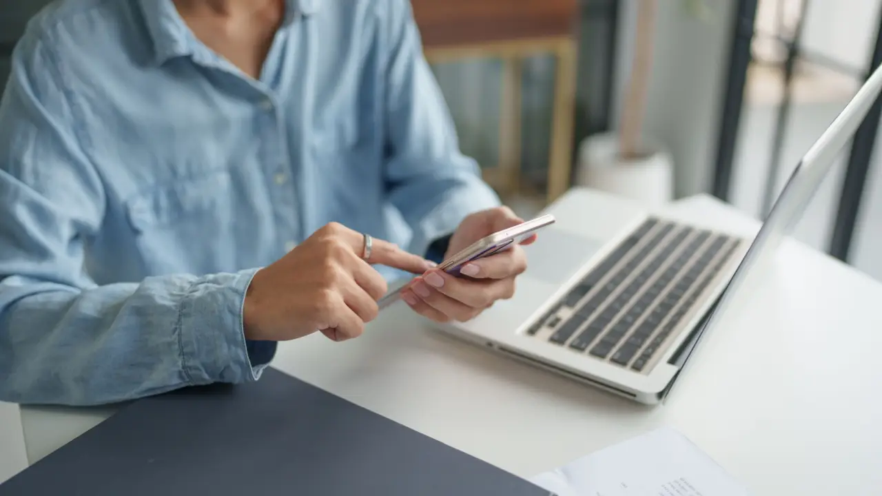Person researching how long do most personal injury cases take to settle using smartphone and laptop in professional office setting