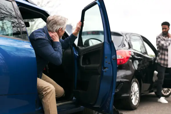 Man holding neck after car accident wondering how much compensation for neck injury in a car accident he can receive