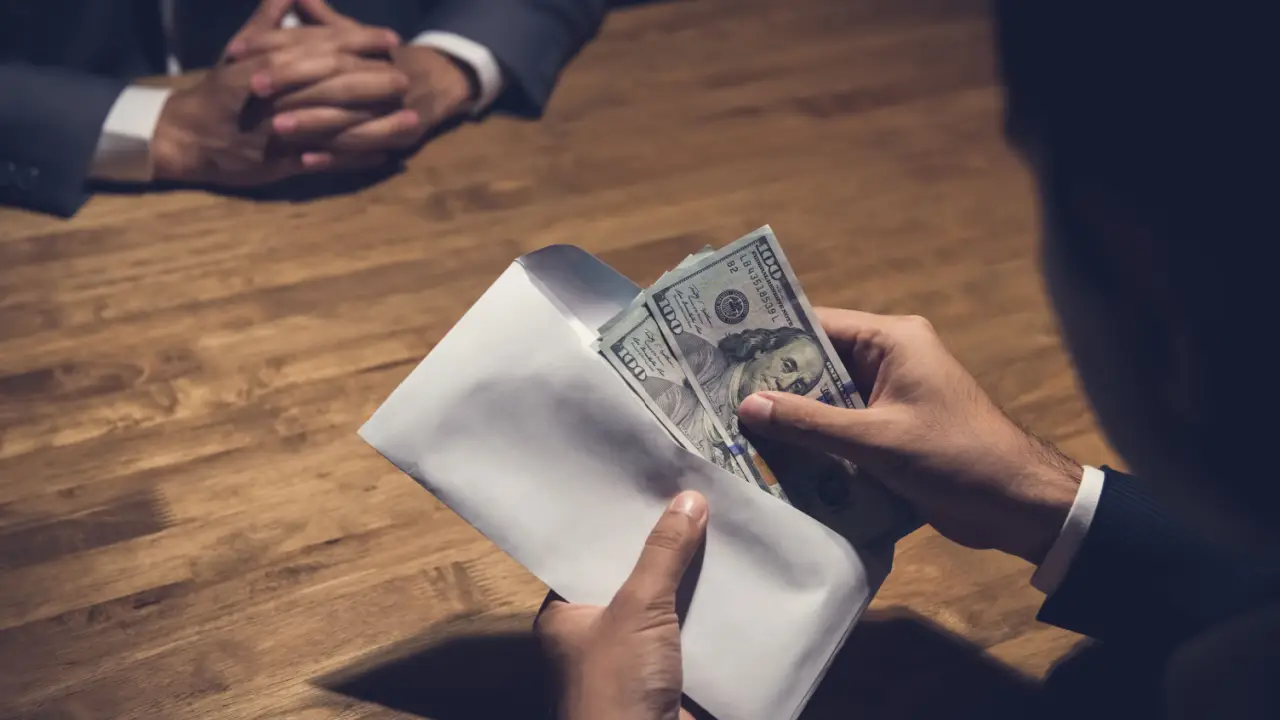 Lawyer handing cash settlement payment to client showing how much settlement for emotional distress cases can provide