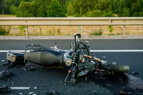 Damaged motorcycle on highway after crash showing why riders need to find the best motorcycle accident lawyer