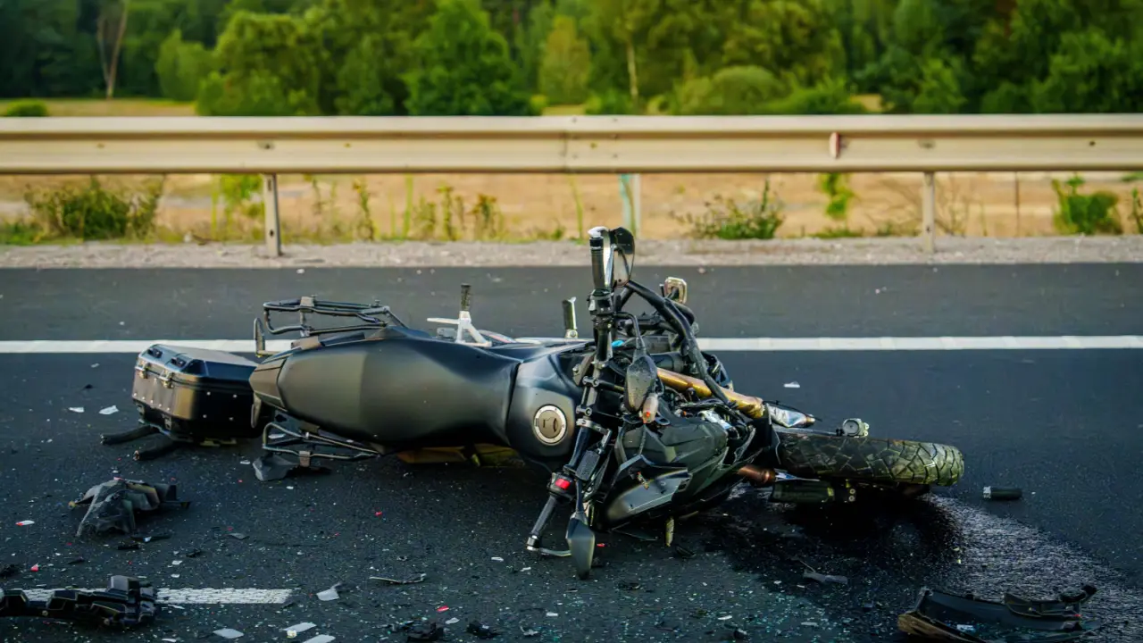 Damaged motorcycle on highway after crash showing why riders need to find the best motorcycle accident lawyer