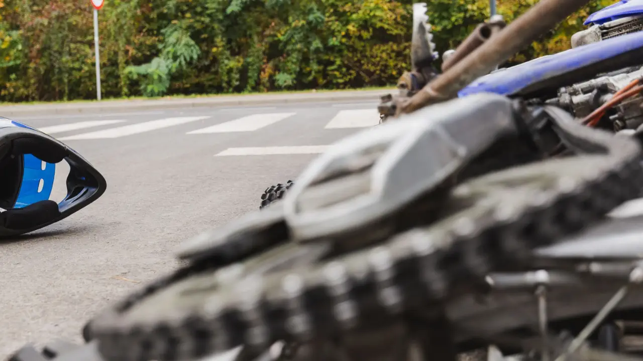 Motorcycle accident scene showing damaged bike on road - how do i find a good motorcycle accident lawyer