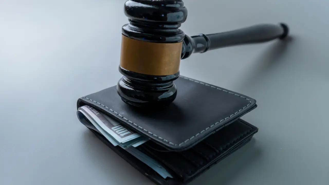 Judge gavel on wallet with cash representing what percent does an injury lawyer take from settlement