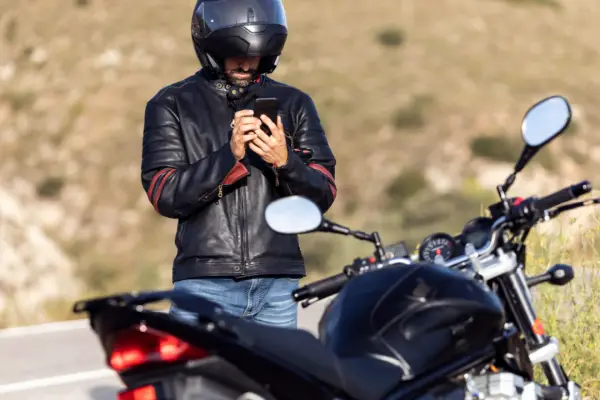 Motorcyclist checking phone after accident learning how to choose a lawyer after motorcycle accident