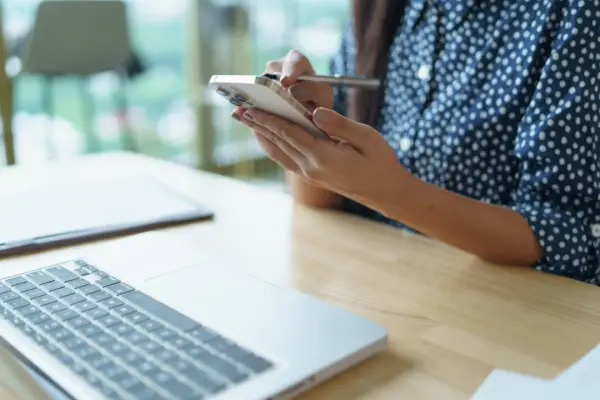 Person researching how hard is it to win a personal injury lawsuit on smartphone and laptop in office setting