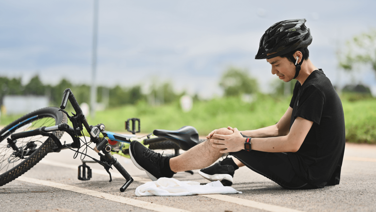 Injured cyclist sitting on road after bike crash documenting evidence of how do you prove fault in a bicycle accident case